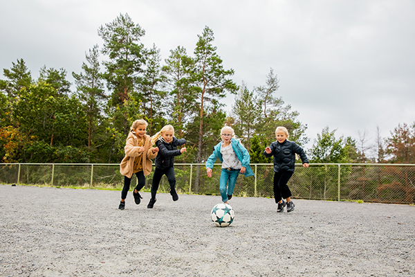 Fyra tjejer springer med en fotboll